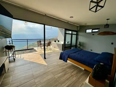 a bedroom with a bed and a balcony with a view at Cabaña en Sopetran con jacuzzi in Sopetran