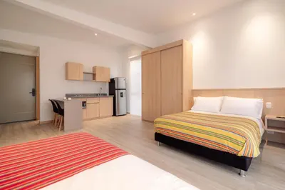 a large bedroom with a bed and a kitchen at Hotel Estar in Manizales