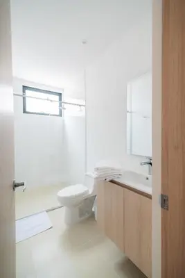 a white bathroom with a toilet and a sink at Hotel Estar in Manizales