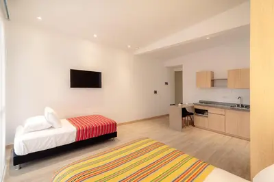 a bedroom with a bed and a kitchen at Hotel Estar in Manizales