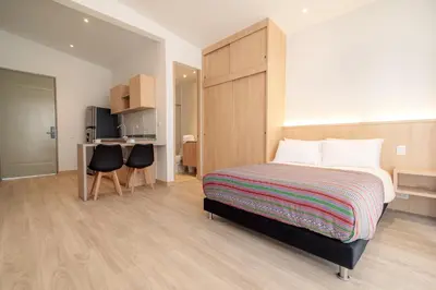a bedroom with a bed and a table and chairs at Hotel Estar in Manizales