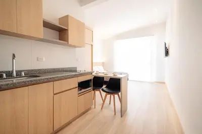 a kitchen with a counter and two chairs in it at Hotel Estar in Manizales