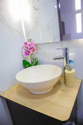 a bathroom sink with a white bowl on a wooden counter at Apartamento cómodo, agradable y económico in Medellín