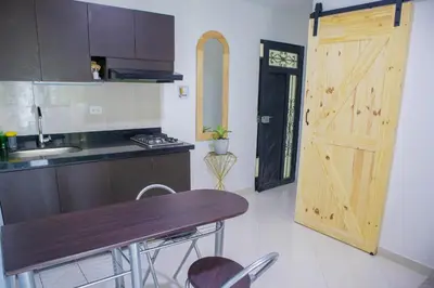 a kitchen with a wooden door and a wooden table at Apartamento cómodo, agradable y económico in Medellín