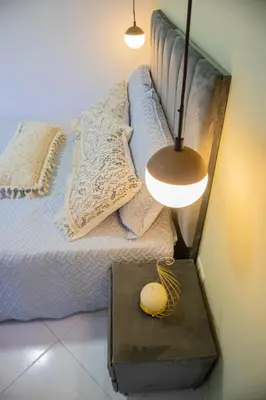 a bedroom with a bed with a table and a lamp at Apartamento cómodo, agradable y económico in Medellín
