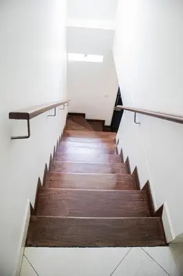 a staircase in a building with white walls and wooden floors at Apartamento cómodo, agradable y económico in Medellín