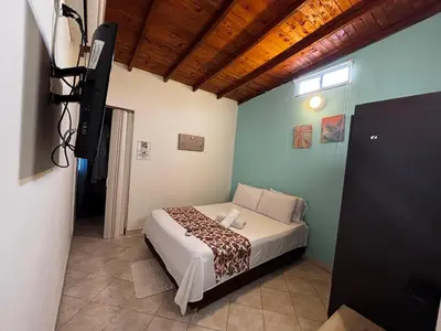 a bedroom with a bed and a flat screen tv at cabaña 83 Santorini in Puerto Triunfo