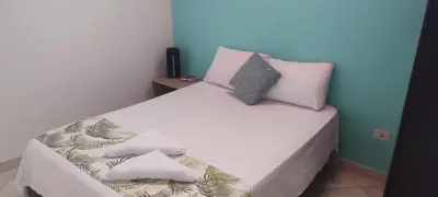 a bedroom with a white bed with pillows on it at cabaña 83 Santorini in Puerto Triunfo