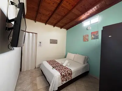 a bedroom with a bed and a television in it at cabaña 83 Santorini in Puerto Triunfo