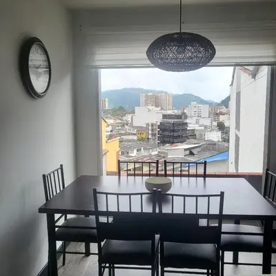 a dining room with a table and chairs and a large window at LA CASA DEL CABLE -Comodo Apartamento 102- in Manizales