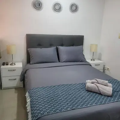 a bedroom with a large bed with two night stands at LA CASA DEL CABLE -Comodo Apartamento 102- in Manizales