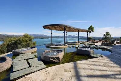 a garden with a pond with rocks and a pavilion at The Brown, Guatape, Autograph Collection in Guatapé