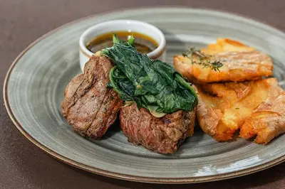 a plate of food with a piece of steak and a side of tempura at The Brown, Guatape, Autograph Collection in Guatapé