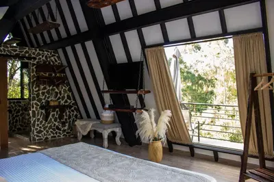 a bedroom with a bed and a large window at Ecoluxury Glamping in San Antonio de Pereira