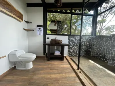 a bathroom with a toilet and a mirror in it at Ecoluxury Glamping in San Antonio de Pereira