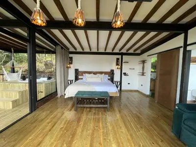 a master bedroom with a bed and a wooden floor at Ecoluxury Glamping in San Antonio de Pereira