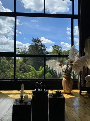 a room with two tables and a large window at Ecoluxury Glamping in San Antonio de Pereira