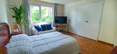 a bedroom with a bed and a tv and a window at Habitación Privada en Apartamento, Conquistadores in Medellín