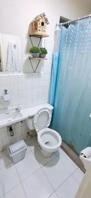 a bathroom with a toilet and a blue shower curtain at Habitación Privada en Apartamento, Conquistadores in Medellín
