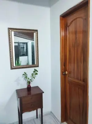 a mirror on a wall next to a wooden door at M76 apartamento acogedor en Medellin in Medellín