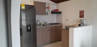 a kitchen with a stainless steel refrigerator and wooden cabinets at M76 apartamento acogedor en Medellin in Medellín