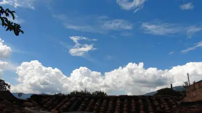 a blue sky with white clouds above a roof at Hostal prado colonial in Medellín