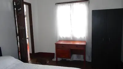 a bedroom with a bed and a dresser and a window at Hostal prado colonial in Medellín