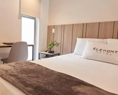 a bedroom with a bed and a desk with a chair at Elemont Hotel in Medellín