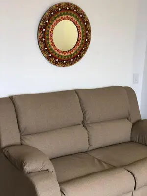 a mirror on the wall above a brown couch at ALTO VERDE HOTEL in Guatapé