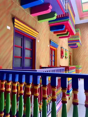 a colorful room with a railing with colorful windows at ALTO VERDE HOTEL in Guatapé