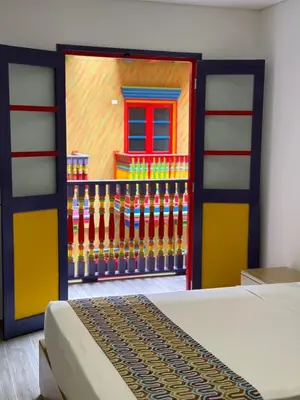 a bedroom with a door with a painting of a fence at ALTO VERDE HOTEL in Guatapé