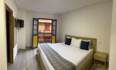 a bedroom with a large bed and a window at ALTO VERDE HOTEL in Guatapé