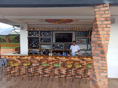 a man standing at a bar in a restaurant at ALTO VERDE HOTEL in Guatapé