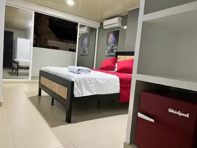 a bedroom with a bed with red pillows at Hotel Entre Parques in La Dorada