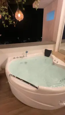 a bath tub filled with water in front of a window at Hotel Entre Parques in La Dorada