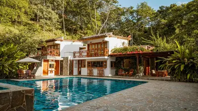 a house with a swimming pool in front of a house at Bio Rio Hotel in San Jerónimo
