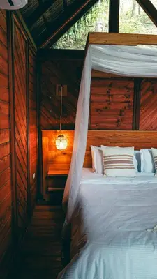 a bedroom with a bed in a wooden cabin at Bio Rio Hotel in San Jerónimo