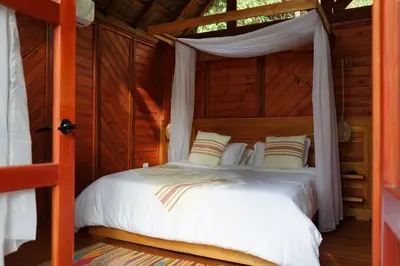 a bedroom with a bed in a wooden cabin at Bio Rio Hotel in San Jerónimo