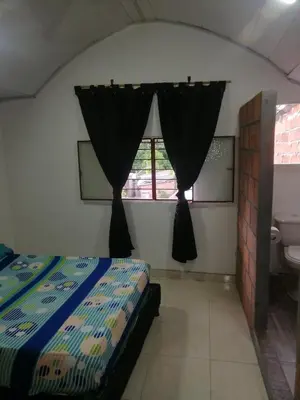 a bedroom with a bed and a sink and a window at casa de relajación lowcost in La Dorada