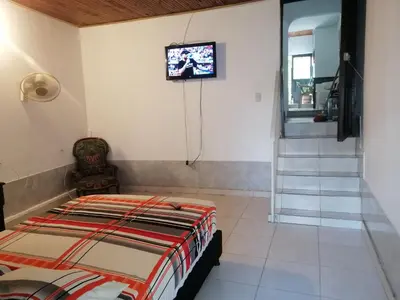 a bedroom with a bed and a tv on the wall at casa de relajación lowcost in La Dorada