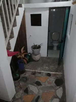 a hallway with a bathroom with a toilet and plants at Casa lowcost relajación total! in La Dorada