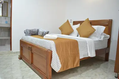a bedroom with a large wooden bed with pillows at HOTEL EL VALENCIA in Sonsón