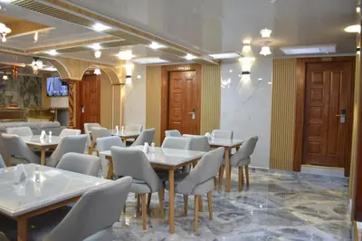 a dining room with tables and white chairs at HOTEL EL VALENCIA in Sonsón