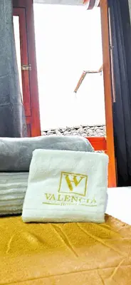 a white towel sitting on top of a bed at HOTEL EL VALENCIA in Sonsón
