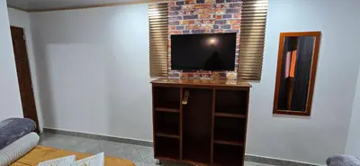 a living room with a flat screen tv on a stand at HOTEL EL VALENCIA in Sonsón