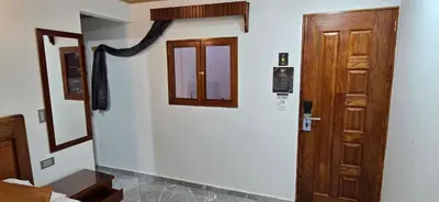 a room with a wooden door and a mirror at HOTEL EL VALENCIA in Sonsón