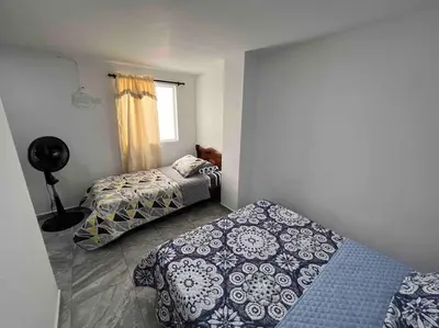 a bedroom with two beds and a window at Sencillo apartamento en Guatape in Guatapé