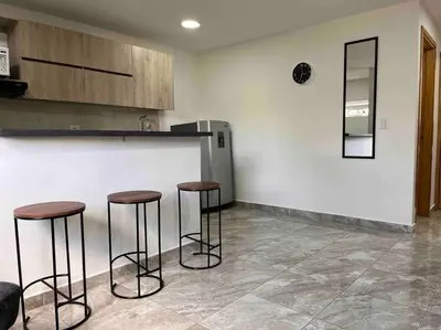 a kitchen with three bar stools in front of a counter at Sencillo apartamento en Guatape in Guatapé