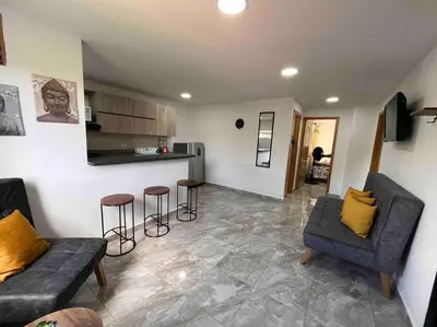 a living room with two couches and a kitchen at Sencillo apartamento en Guatape in Guatapé