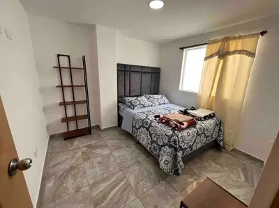 a small bedroom with a bed and a window at Sencillo apartamento en Guatape in Guatapé